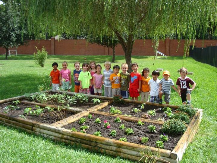 Kids and teacher standing around garden