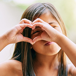 Child making heart with hands