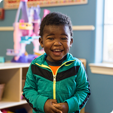 Boy smiling in toddler classroom