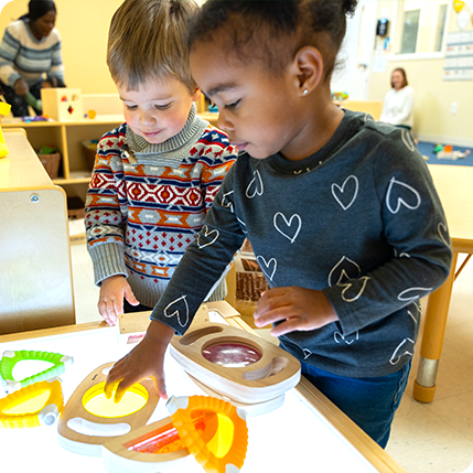 Two children working at the light table