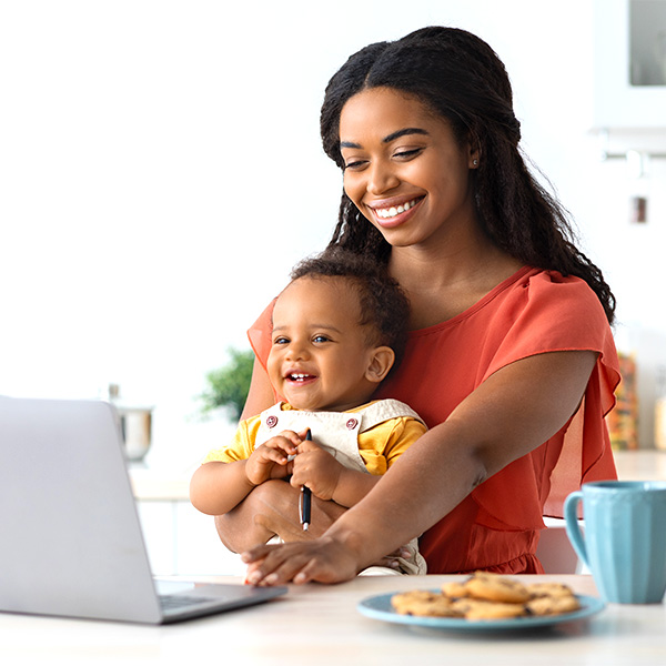 Mom working at laptop with child on lap