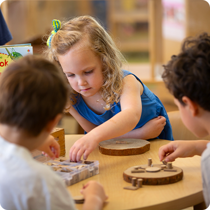 preschool children working on puzzles at a table