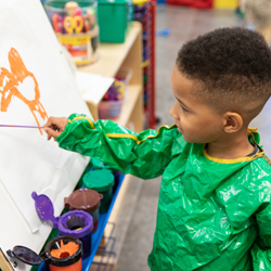 Boy painting at easel