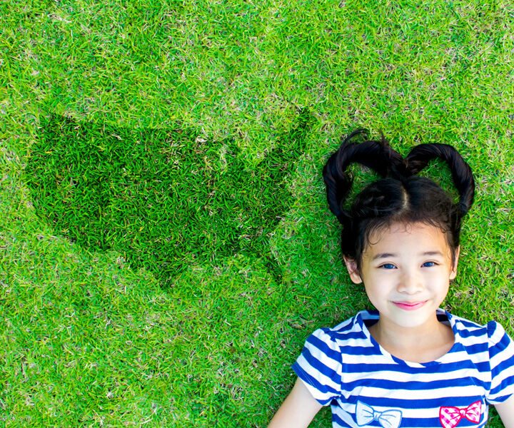 Girl laying on grass with a map image next to her