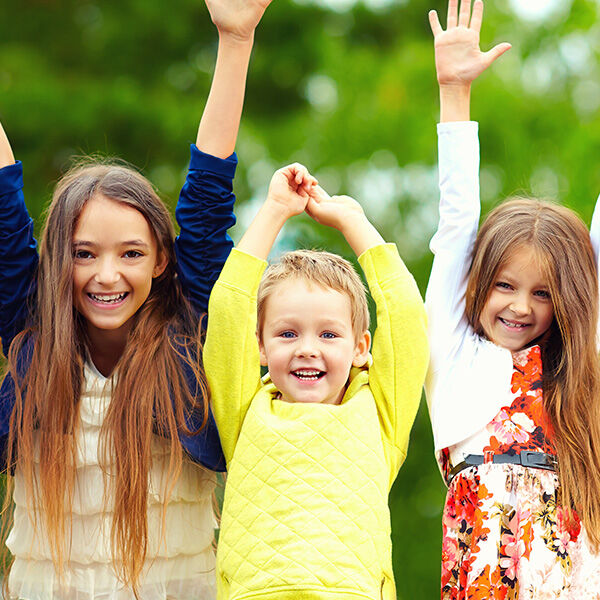 Kids smiling with arms up in air