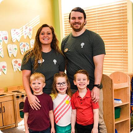 teachers and preschool students smiling in classroom