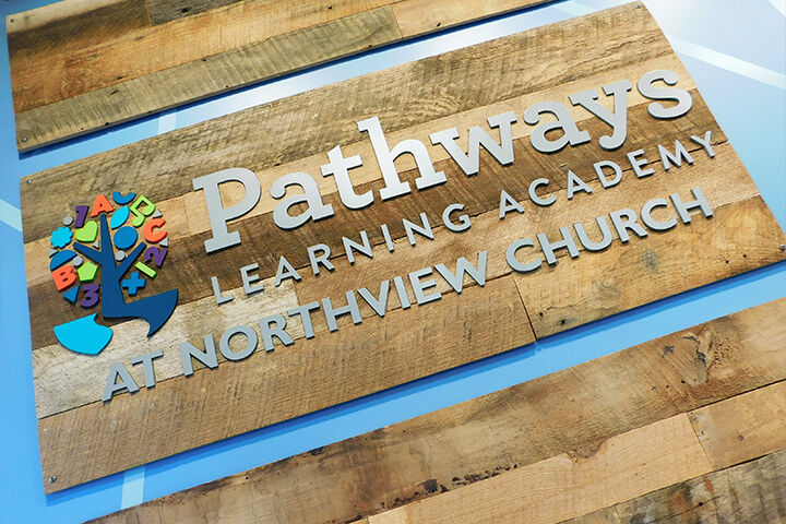 Pathways Learning Academy logo against wood wall
